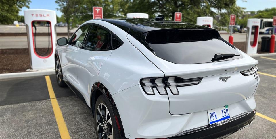 a mustang mach e at at tesla charging station