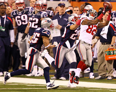 New York Giants wide receiver Victor Cruz (C) catches a two-yard touchdown  pass against New England Patriots safety James Ihedigbo during the first  quarter at Super Bowl XLVI at Lucas Oil Stadium