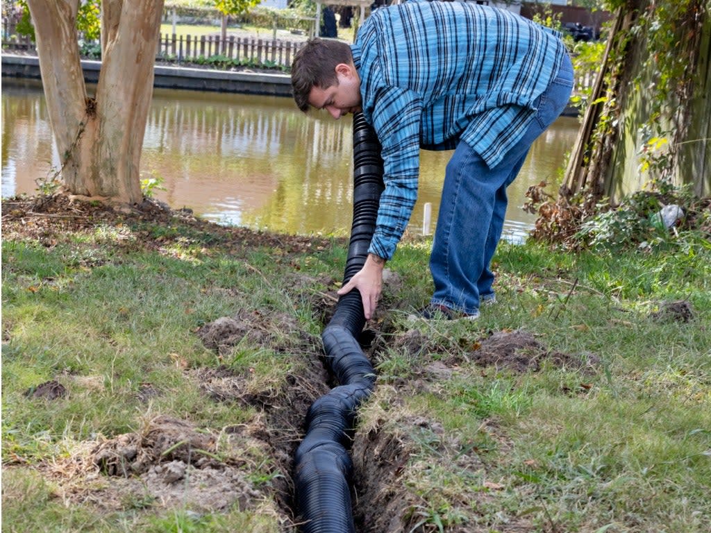 Trench is dug to lay new pipe tubing to drain water away from the home