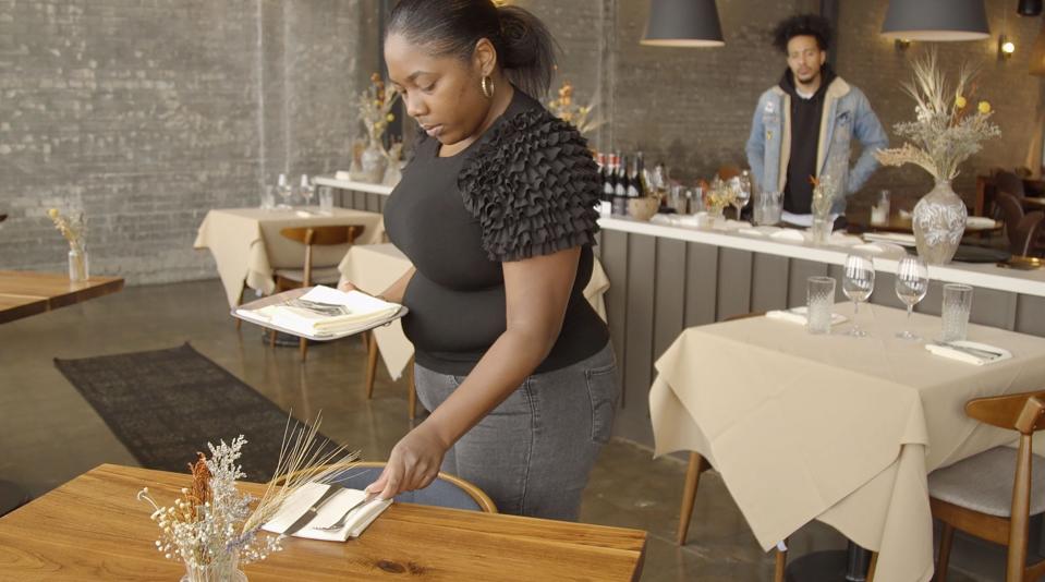 Thor Jones, right, watches Markeisha Wesley work on a table setup at Freya during a Full Hands In Full Hands Out class on March 30, 2022. The class gives students the tools they need to gain employment in the restaurant industry.