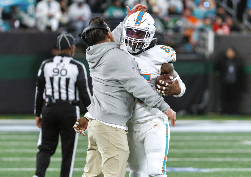 Miami Dolphins linebacker Jerome Baker (55) celebrates with linebackers coach Anthony Campanile after intercepting a New York Jets pass during the fourth quarter of an NFL football game Friday, Nov. 24, 2023, in East Rutherford, N.J. (David Santiago/Miami Herald via AP)