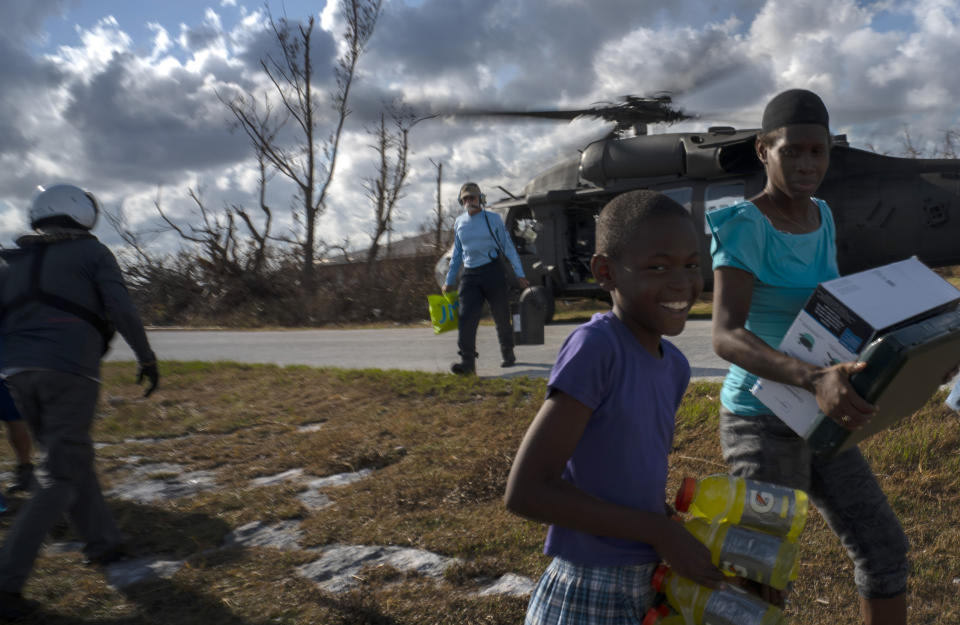 Ayfon Minus, 8, collects donated food that was brought by helicopter from Freeport to the Hurricane Dorian destroyed village of High Rock, Grand Bahama, Bahamas, Tuesday, September 10, 2019. (AP Photo/Ramon Espinosa)