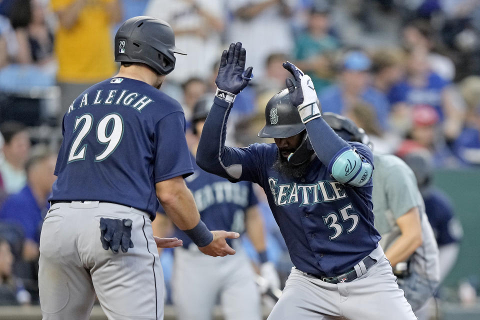 Seattle Mariners' Teoscar Hernandez (35) celebrates with Cal Raleigh (29) after hitting a two-run home run during the fourth inning of a baseball game against the Kansas City Royals Tuesday, Aug. 15, 2023, in Kansas City, Mo. (AP Photo/Charlie Riedel)