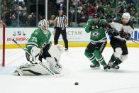 Dallas Stars goaltender Braden Holtby (70) deflects a shot at the net as Stars defenseman Andrej Sekera (5) and Arizona Coyotes' Liam O'Brien, right, chase after control of the puck in the second period of an NHL hockey game in Dallas, Monday, Dec. 6, 2021. (AP Photo/Tony Gutierrez)