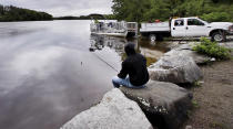 <p>Kevin Garcia fishes along the banks of the Merrimack River as a “Clean River Project” recovery boat is offloaded in Chelmsford, Mass. Syringes left by drug users amid the heroin crisis are turning up everywhere. They hide in weeds along hiking trails and in playground grass, get washed into rivers and onto beaches, and lie scattered about in baseball dugouts and on sidewalks and streets. There are reports of children finding them and getting poked. (Photo: Charles Krupa/AP) </p>