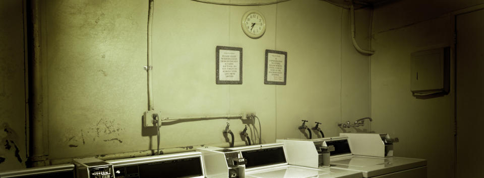 A dimly lit basement with washers and dryers