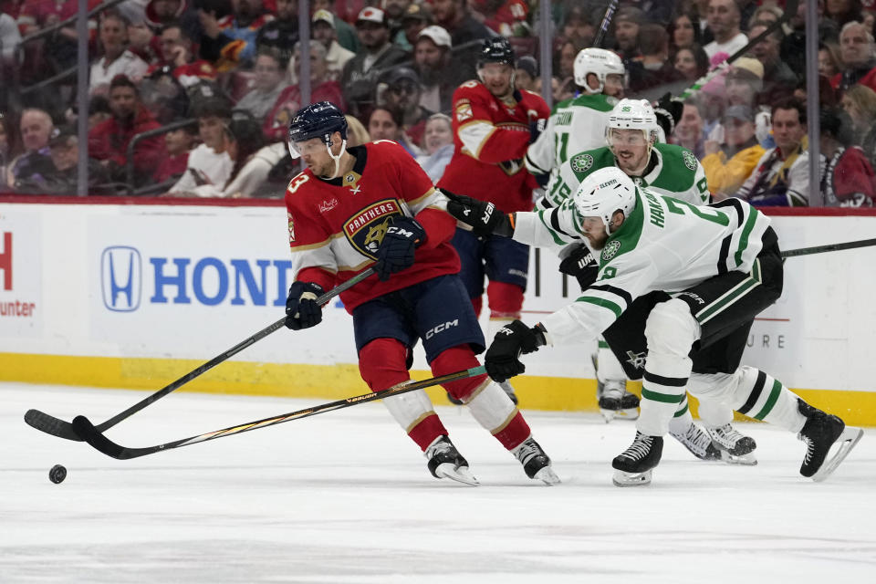 Florida Panthers center Sam Reinhart (13) skates with the puck as Dallas Stars defenseman Jani Hakanpaa (2) defends during the second period of an NHL hockey game, Wednesday, Dec. 6, 2023, in Sunrise, Fla. (AP Photo/Lynne Sladky)