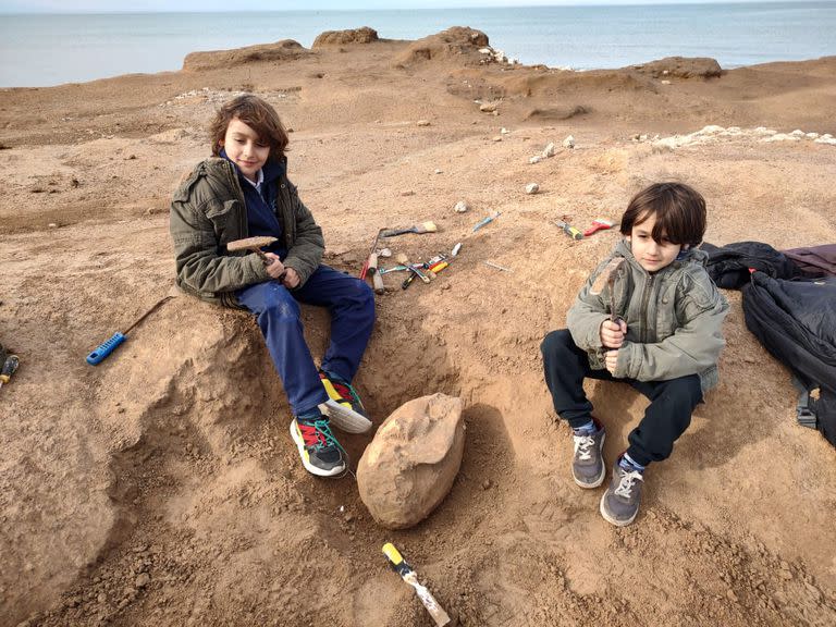 Vicente Di Iorio (izquierda) junto al cráneo que halló de un animal prehistórico y a su hermano Benjamín