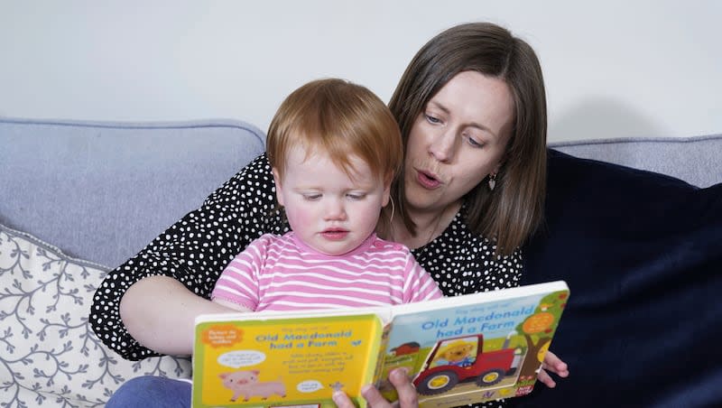 Opal Sandy, who was born completely deaf because of a rare genetic condition and can now hear unaided for the first time after receiving groundbreaking gene therapy at 11 months old, reads with her mother, Jo, at their home in Eynsham, Oxfordshire.