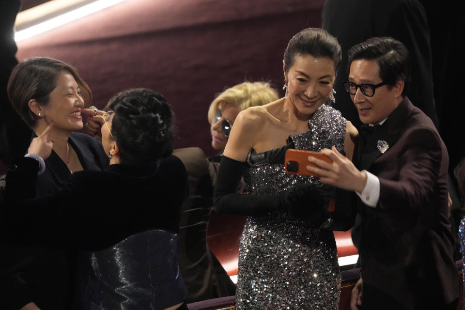 Michelle Yeoh, left, and Ke Huy Quan take a selfie during the Oscars on Sunday, March 10, 2024, at the Dolby Theatre in Los Angeles. (AP Photo/Chris Pizzello)