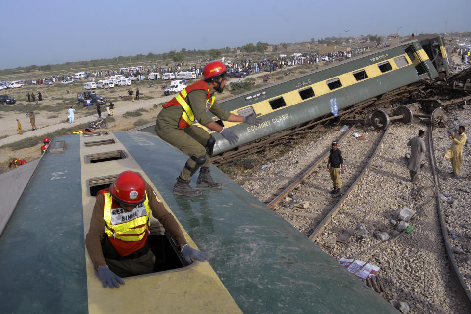 Rescue workers look survivors at the site of a passenger train derailed near Nawabshah, Pakistan, Sunday, Aug. 6, 2023. Railway officials say some passengers were killed and dozens more injured when a train derailed near the town of Nawabshah in southern Sindh province. (AP Photo/Umair Ali)