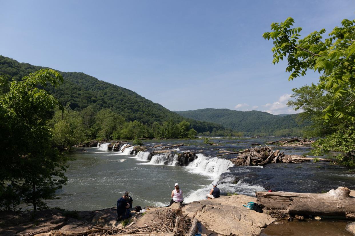 People Fishing at the Sandstone Falls, in the New River, during summer, located at Shady Spring, West Virginia