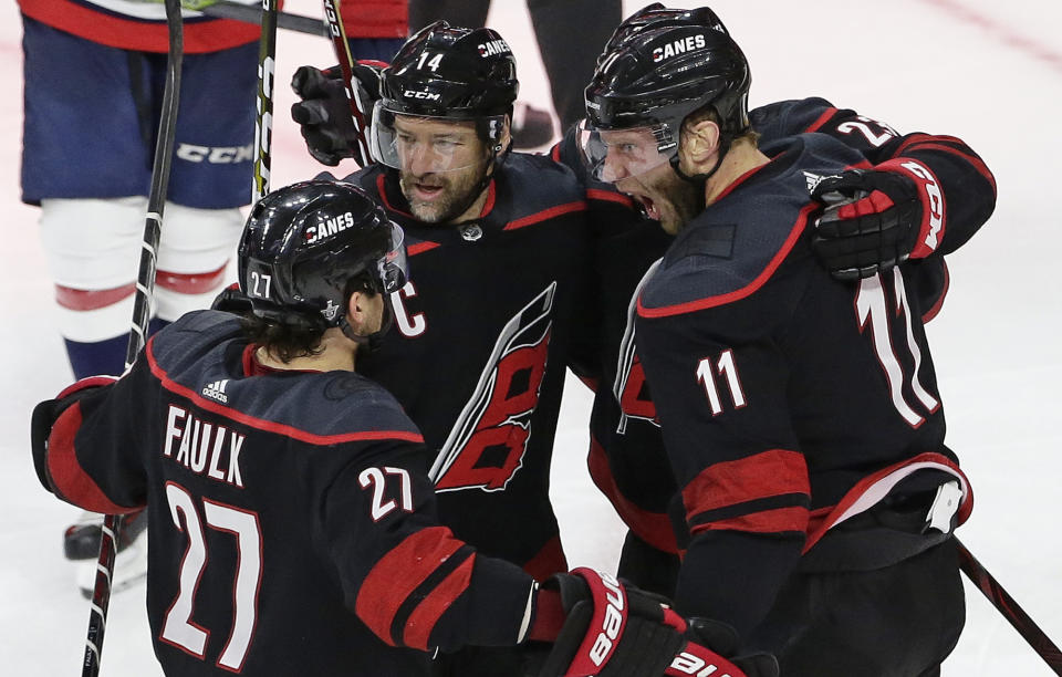 Carolina Hurricanes' Jordan Staal (11), Justin Faulk (27) and Justin Williams (14) celebrate Staal's goal against the Washington Capitals during the third period of Game 6 of an NHL hockey first-round playoff series in Raleigh, N.C., Monday, April 22, 2019. (AP Photo/Gerry Broome)