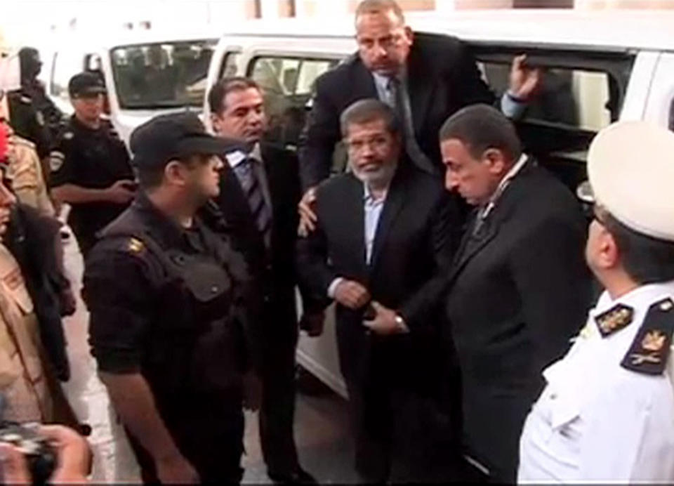 FILE - This Monday, Nov. 3, 2013 file image made from video provided by Egypt's Interior Ministry shows ousted President Mohammed Morsi, center, arriving for a trial hearing in Cairo, Egypt after four months in secret detention. Egypt’s crackdown on Islamists has jailed 16,000 people over the past eight months in the country’s biggest round-up in nearly two decades, according to previously unreleased figures from security officials. Rights activists say reports of abuses in prisons are mounting, with prisoners describing systematic beatings and miserable conditions for dozens packed into tiny cells. (AP Photo/Egyptian Interior Ministry, File)