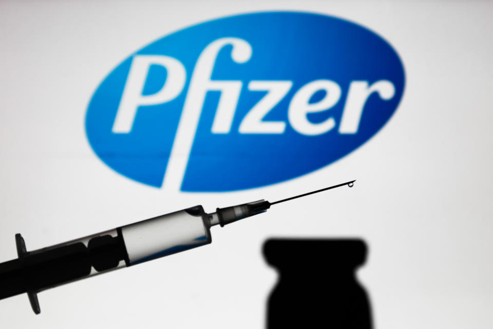 Medical syringe is seen with Pfizer company logo displayed on a screen in the background in this illustration photo taken in Poland on November 16, 2020. (Photo by Jakub Porzycki/NurPhoto via Getty Images)