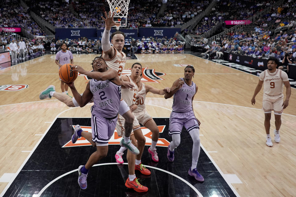 Kansas State guard Tylor Perry (2) looks to shoot under pressure from Texas guard Chendall Weaver (2) during the first half of an NCAA college basketball game Wednesday, March 13, 2024, in Kansas City, Mo. (AP Photo/Charlie Riedel)