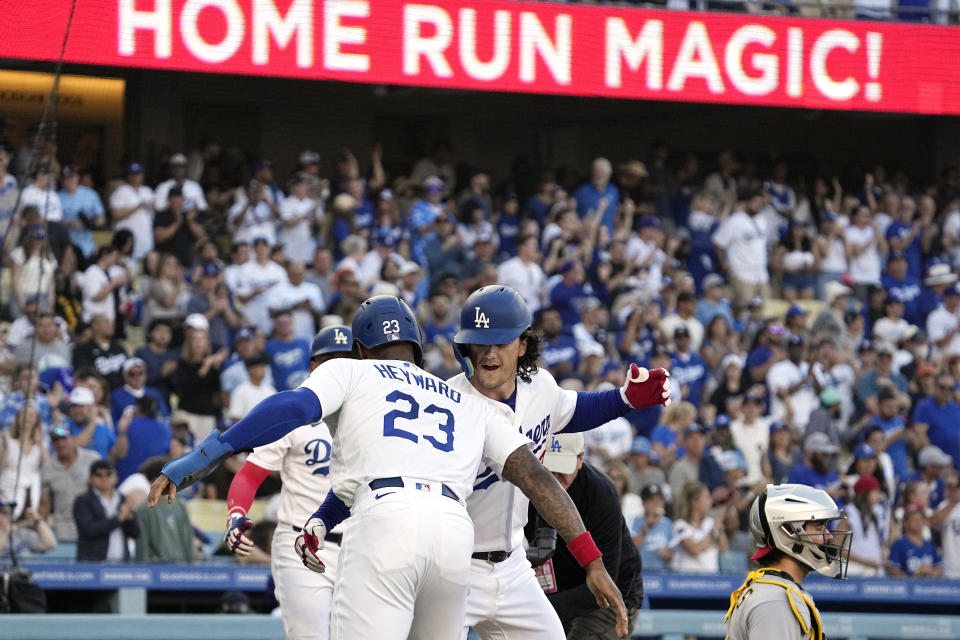 Los Angeles Dodgers' James Outman, second from right, is congratulated by Jason Heyward, left, after hitting a two-run home run as Pittsburgh Pirates catcher Austin Hedges kneels at the plate during the second inning of a baseball game Tuesday, July 4, 2023, in Los Angeles. (AP Photo/Mark J. Terrill)