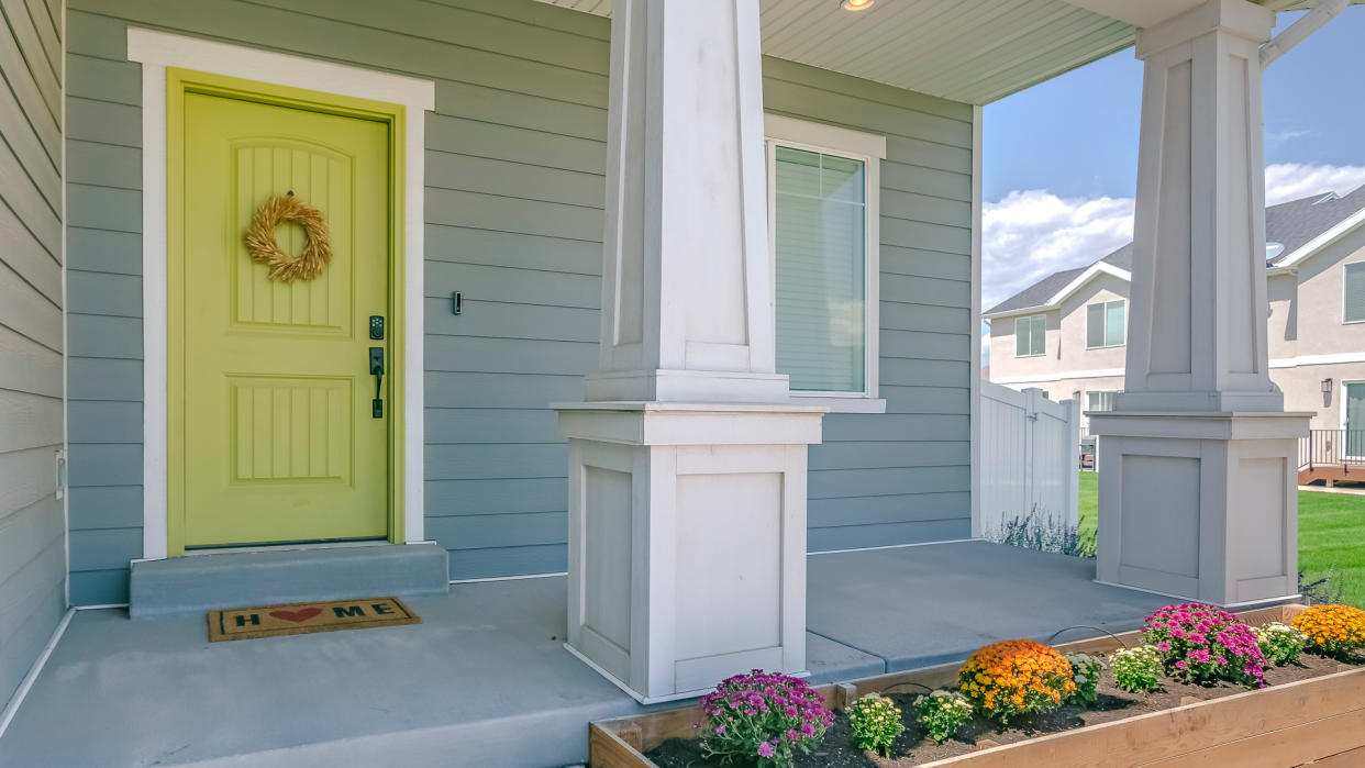 Home with porch and flowers in the garden.