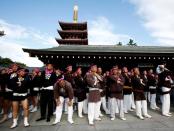 FILE PHOTO: People wait their turns to carry a portable shrine, a Mikoshi, at the Senso-ji Temple during the Sanja festival in Asakusa district in Tokyo