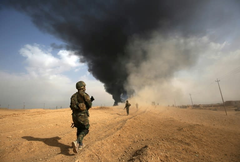 Iraqi forces and members of the Hashed al-Shaabi (Popular Mobilisation units) advance towards the city of Al-Qaim, near Syria during the fight against remnant pockets of Islamic State group jihadists on November 3, 2017