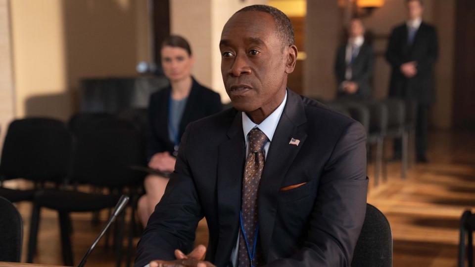 Don Cheadle sitting at a table in a suit in Secret Invasion