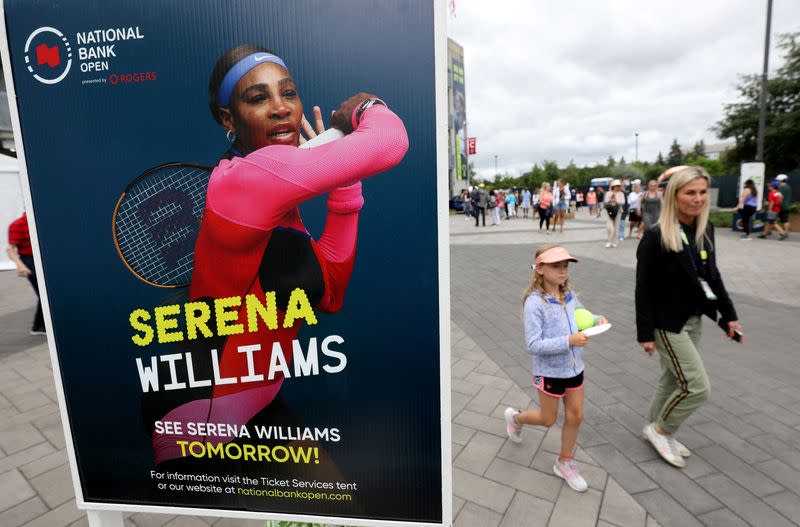 FOTO DE ARCHIVO: Un grupo de personas pasa junto a un cartel que anuncia el partido de Serena Williams, a las afueras de un estadio en el National Bank Open en Toronto