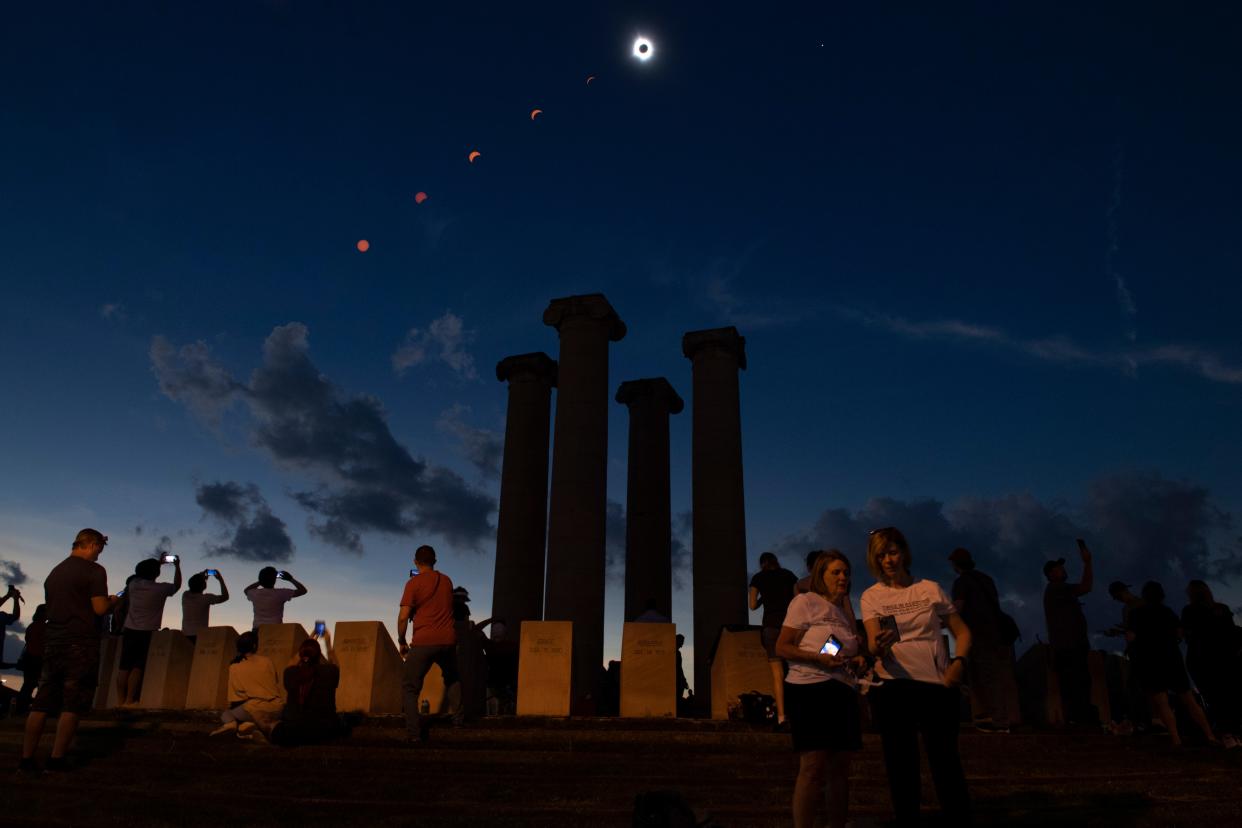 The progression of the total solar eclipse is shown above the Four Freedoms Monument during totality in this composite image of seven photos taken between 12:45 p.m. and 2:05 p.m. on Monday, April 8, 2024, photographed in downtown Evansville, Indiana.