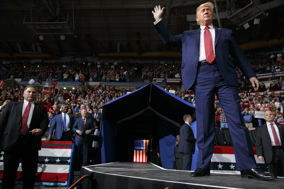 President Donald Trump waves as he arrives in North Charleston, S.C., for a campaign rally, Friday Feb. 28, 2020. Attending the rally are Sen. Lindsey Graham, R-S.C., center, and Sen. Tim Scott, R-S.C., left. (AP Photo/Jacquelyn Martin)