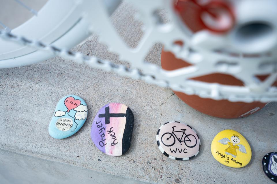 A painted rocks sit by a ghost bicycle that memorializes two cyclists who were killed in a 2023 bike crash that left another 19 people injured, on the South Cotton Lane bridge over the Gila River, photographed on March 14, 2024, in Goodyear.