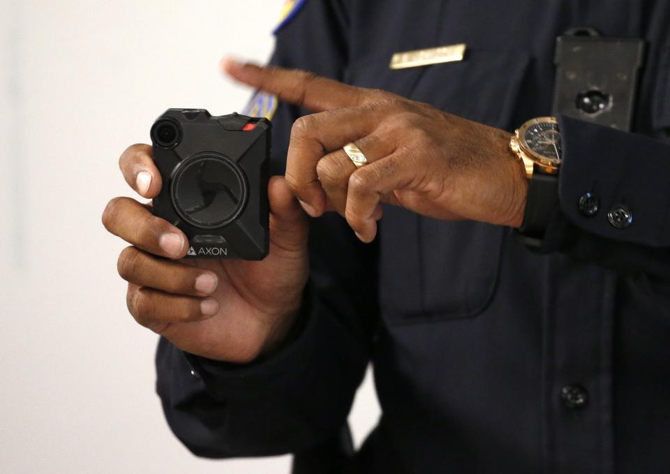 Phoenix Police Department Sgt. Kevin Johnson demonstrates the new Axon Body 2 body camera to fellow officers as another precinct gets their cameras assigned to them Wednesday, July 3, 2019, in Phoenix. Although body-worn cameras are becoming a police standard nationwide, Phoenix was among the last big departments to adopt their widespread use. (AP Photo/Ross D. Franklin)