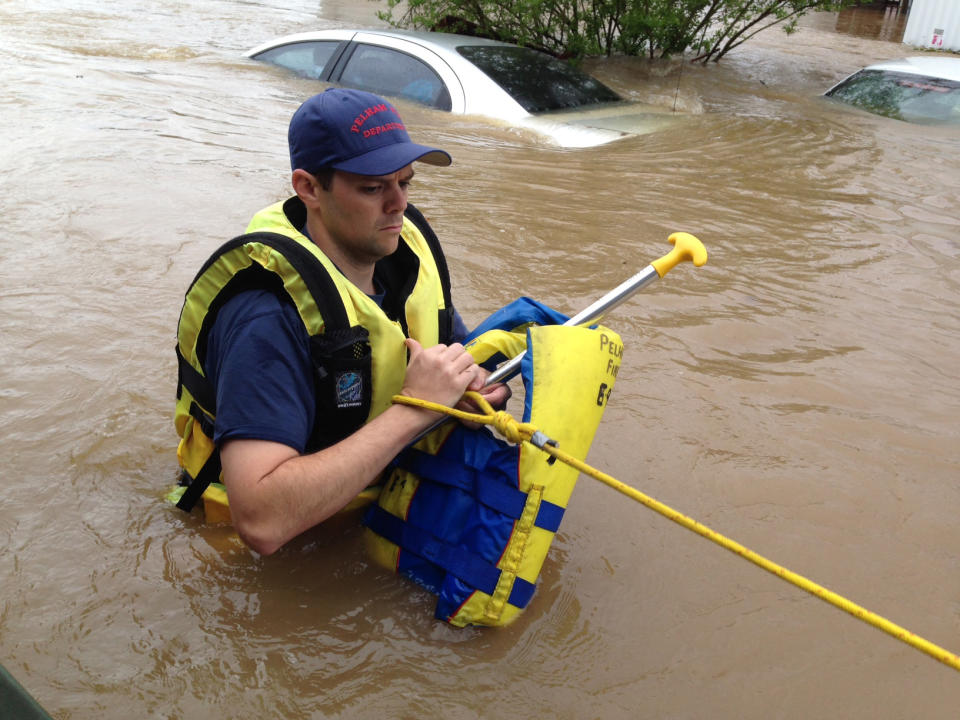 Firefighter Rusty Murphy wades through flood waters in a mobile home park in Pelham, Ala., on Monday, April 7, 2014. Police and firefighters rescued about a dozen people who were trapped by muddy, fast-moving water after storms dumped torrential rains in central Alabama. (AP Photo/Jay Reeves)