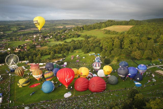 Dozens of hot air balloons are inflated ahead of lift off (Ben Birchall/PA)