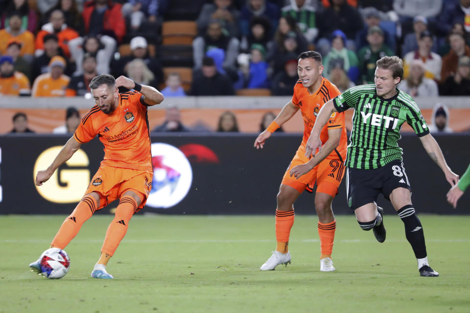 Houston Dynamo midfielder Hector Herrera, left, attempts a shot on goal in front of forward Sebastian Ferreira (9) and Austin FC midfielder Alexander Ring (8) during the second half of an MLS soccer match Saturday, March 18, 2023, in Houston. (AP Photo/Michael Wyke)