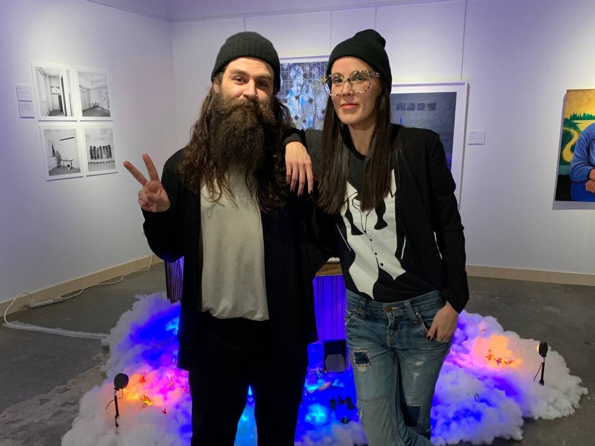 Sarah Swan, right, director with the Yellowknife Artist Run Community Centre (YK ARCC), with artist Sami Blanco in front of Blanco's installation at the city's visitor centre gallery. YK ARCC will be curating at least 4 new shows in the space this coming year. (Submitted by Sarah Swan - image credit)