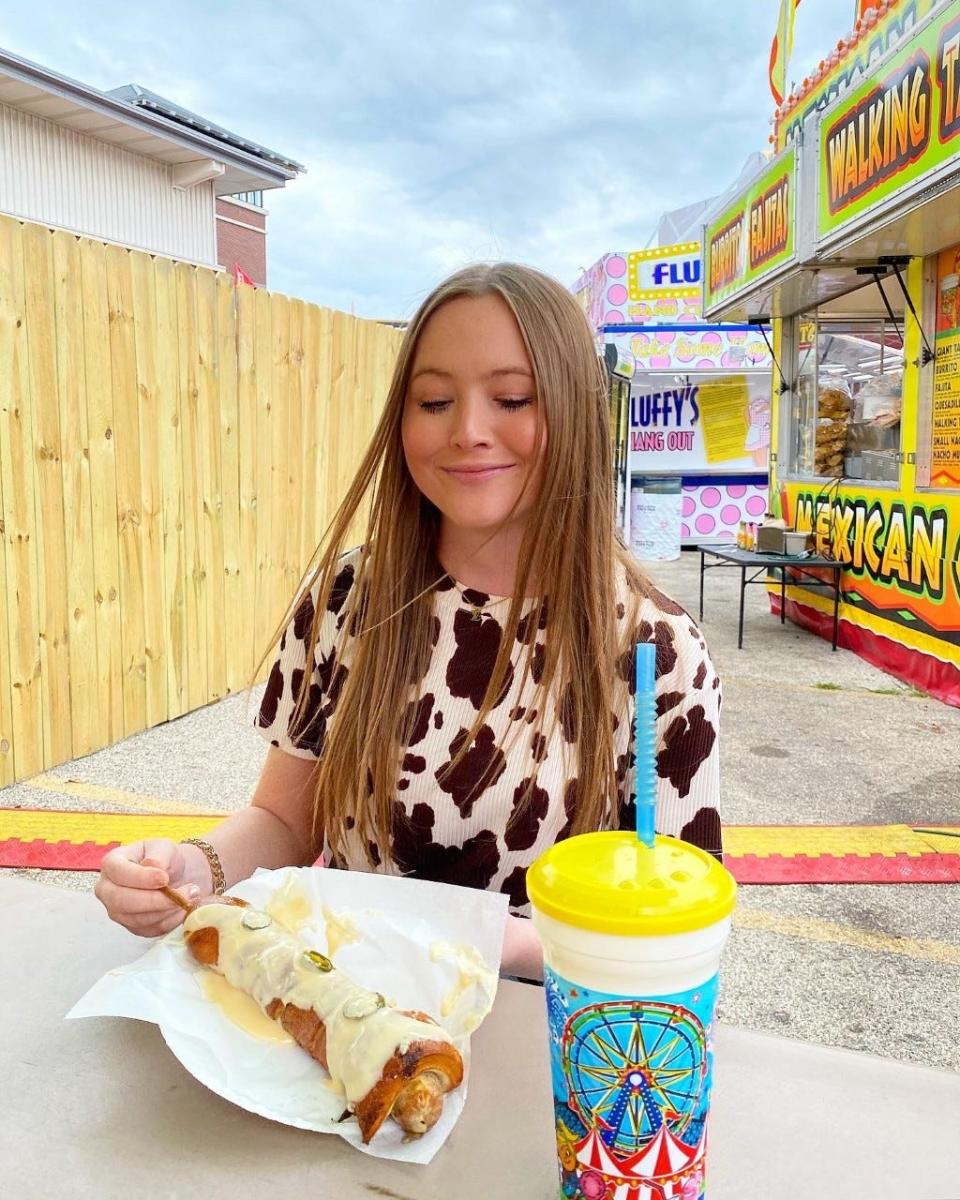 Be MKE Aug. 17, 2022: Hannah Kirby with The Peno Pretzel Popper Brat from Gertrude's Pretzels at the Wisconsin State Fair on Aug. 13, 2022.