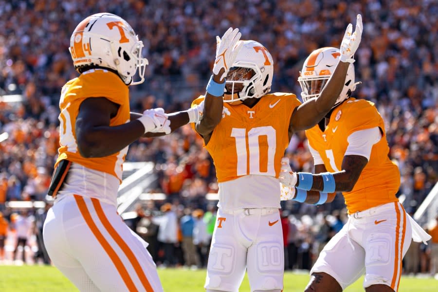 Tennessee wide receiver Squirrel White (10) celebrates a touchdown with teammates Kaleb Webb (84) and Dont’e Thornton Jr. (1) during the first half of an NCAA college football game against UConn, Saturday, Nov. 4, 2023, in Knoxville, Tenn. (AP Photo/Wade Payne)