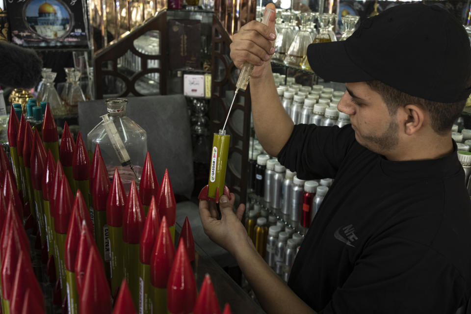 Belal Abu Saraya fills a perfume container representing rockets used against Israel in a perfume store against Israel in past conflicts at his shop in Gaza City on Thursday, Oct. 5, 2023. AP Photo/Fatima Shbair)