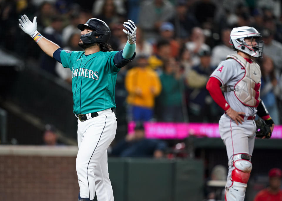 Seattle Mariners' Eugenio Suarez celebrates his solo home run, near Los Angeles Angels catcher Logan O'Hoppe during the fifth inning of a baseball game Tuesday, Sept. 12, 2023, in Seattle. (AP Photo/Lindsey Wasson)