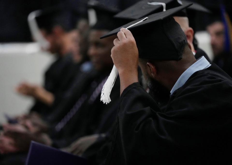 A man moves his tassle from one side of his cap to the other during a college graduation ceremony at Grafton Correctional Institution in northeastern Ohio.