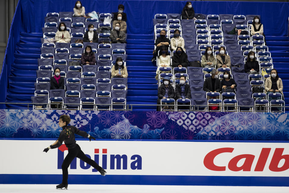 Spectators watch Sena Miyake of Japan warm up during a practice session of an ISU Grand Prix of Figure Skating competition in Kadoma near Osaka, Japan, Friday, Nov. 27, 2020. The event was held with limited spectator attendance Friday. (AP Photo/Hiro Komae)