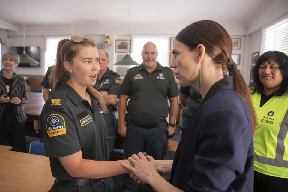 New Zealand's Prime Minister Jacinda Ardern, right, talks with first responders in Whakatane, New Zealand, Tuesday, Dec. 10, 2019. A volcanic island in New Zealand erupted Monday Dec. 9 in a tower of ash and steam while dozens of tourists were exploring the moon-like surface, killing multiple people and leaving many more missing.(Dom Thomas/Pool Photo via AP)