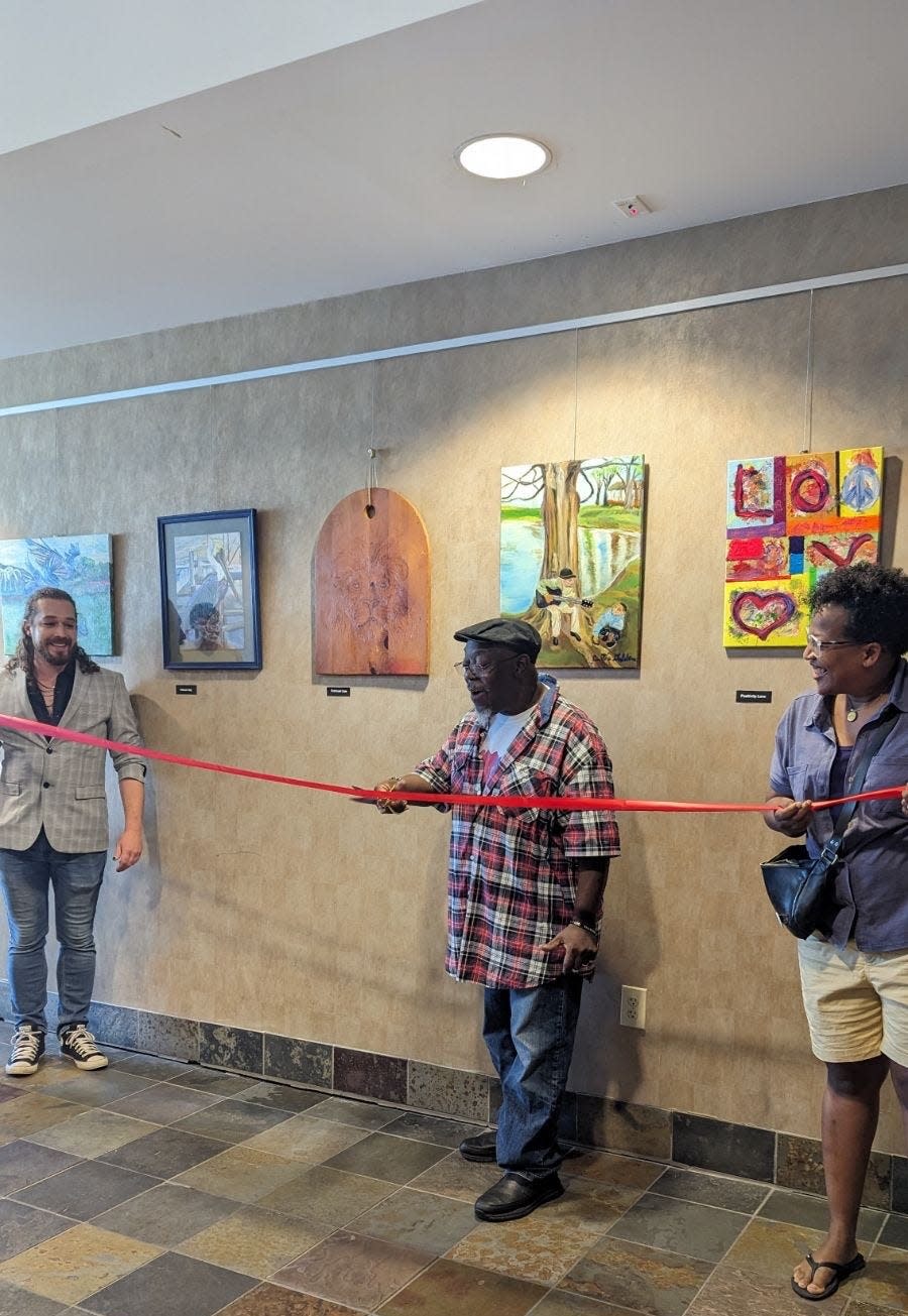 Columbus artist Curtis Golden is flanked by two Equitas Health staff members at the ribbon-cutting for his exhibit in the ART UP Gallery at the Equitas Health King-Lincoln Community Health Center & Pharmacy.