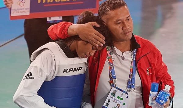 Timor Leste taekwondo athlete Ana Da Costa had to be consoled by her coach after losing her final and the opportunity to win gold. (PHOTO: Facebook)