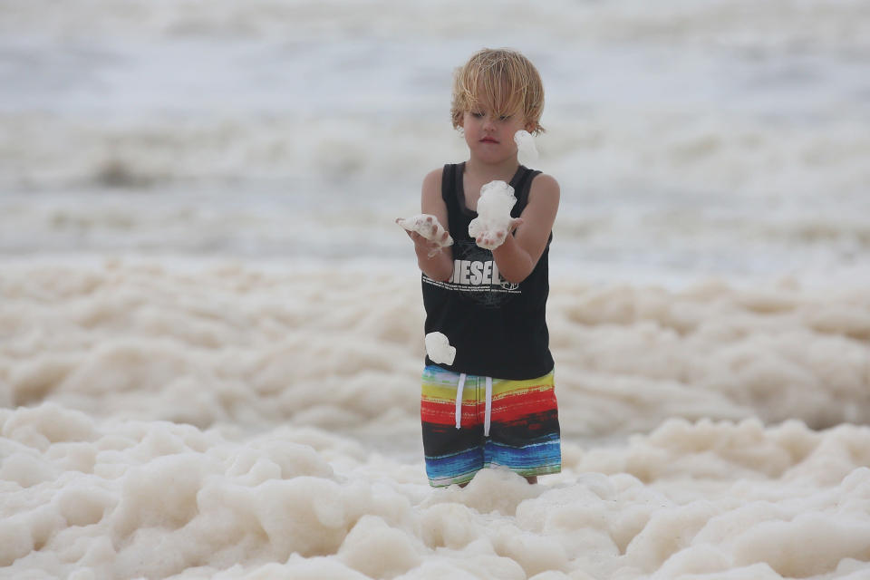A child plays with ocean foam in Burleigh Heads as Queensland experiences severe rains and flooding from Tropical Cyclone Oswald on January 28, 2013 in Gold Coast, Australia. Hundreds have been evacuated from the towns of Gladstone and Bunderberg while the rest of Queensland braces for more flooding. (Photo by Chris Hyde/Getty Images)