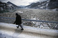 A man walks by tons of garbage stuck at the foot of the hydro power plant at the Potpecko accumulation lake near Priboj, in southwest Serbia, Friday, Jan. 22, 2021. Serbia and other Balkan nations are virtually drowning in communal waste after decades of neglect and lack of efficient waste-management policies in the countries aspiring to join the European Union. (AP Photo/Darko Vojinovic)