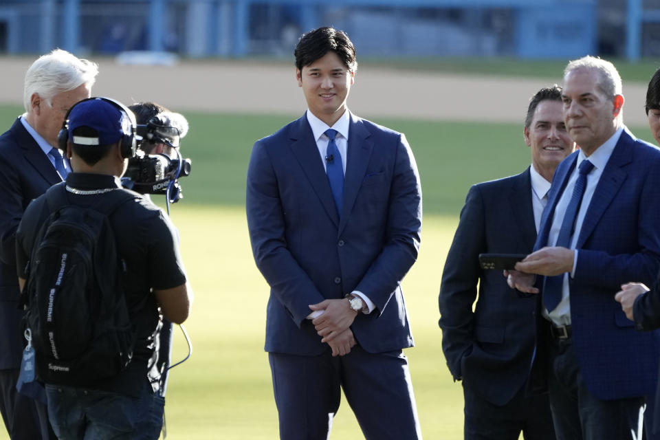 Los Angeles Dodgers' Shohei Ohtani, middle, arrives at a baseball news conference at Dodger Stadium Thursday, Dec. 14, 2023, in Los Angeles. (AP Photo/Marcio Jose Sanchez)