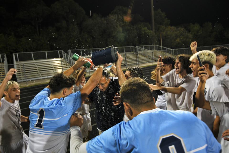 West Boca head coach Hassan Jaddaoui is doused with a celebratory Gatorade bath by his players following his squad's district championship win (Jan. 31, 2023).