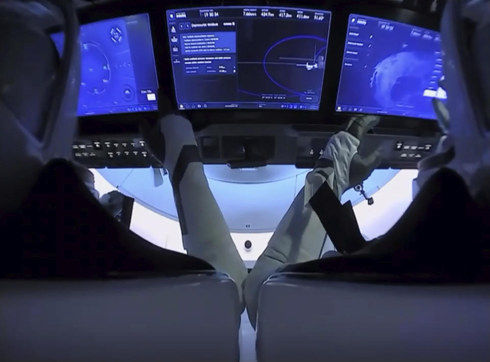 In this image from video made available by NASA, astronauts Doug Hurley, left, and Bob Behnken prepare for undocking from the International Space Station, aboard the SpaceX Crew Dragon capsule on Saturday, Aug. 1, 2020. (NASA via AP)