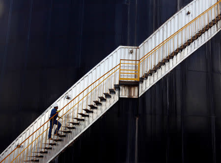 FILE PHOTO - An employee of the Canadian Pacific Rubiales Petroleum Company ascends an oil storage tank in Campo Rubiales field in Meta, eastern Colombia April 21, 2010. REUTERS/Jose Miguel Gomez/File Photo