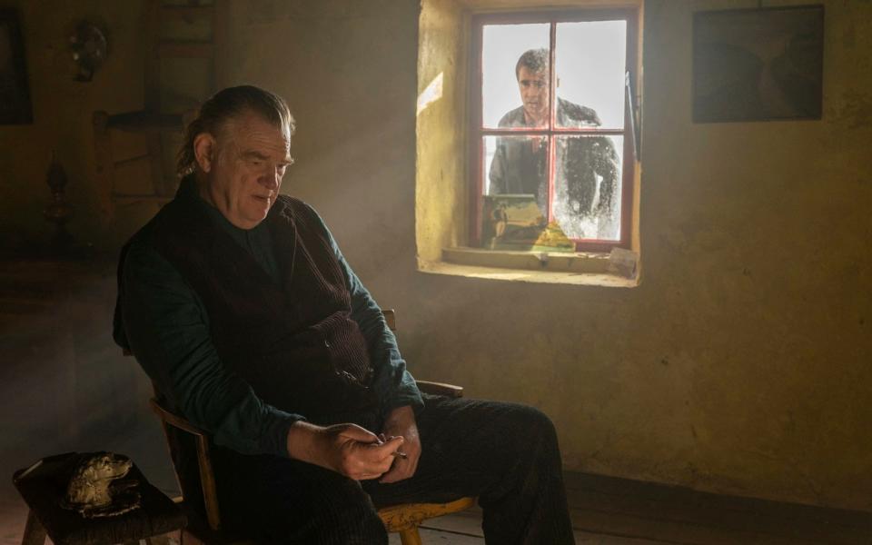 Brendan Gleeson sitting in a chair, Colin Farrell looking in from a window outside